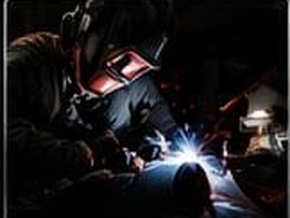 Welder performing custom metal fabrication in the shop